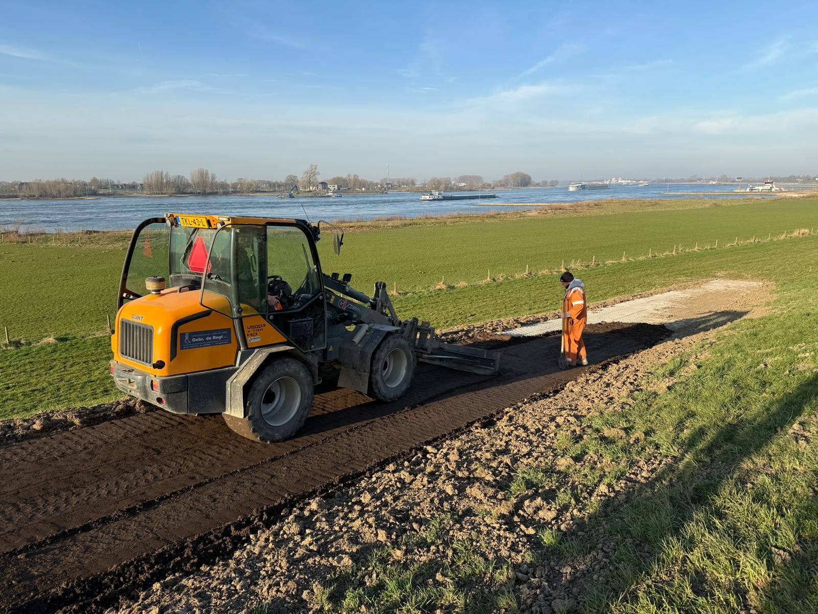 Shovel verplaatst grond tijdens grondwerk